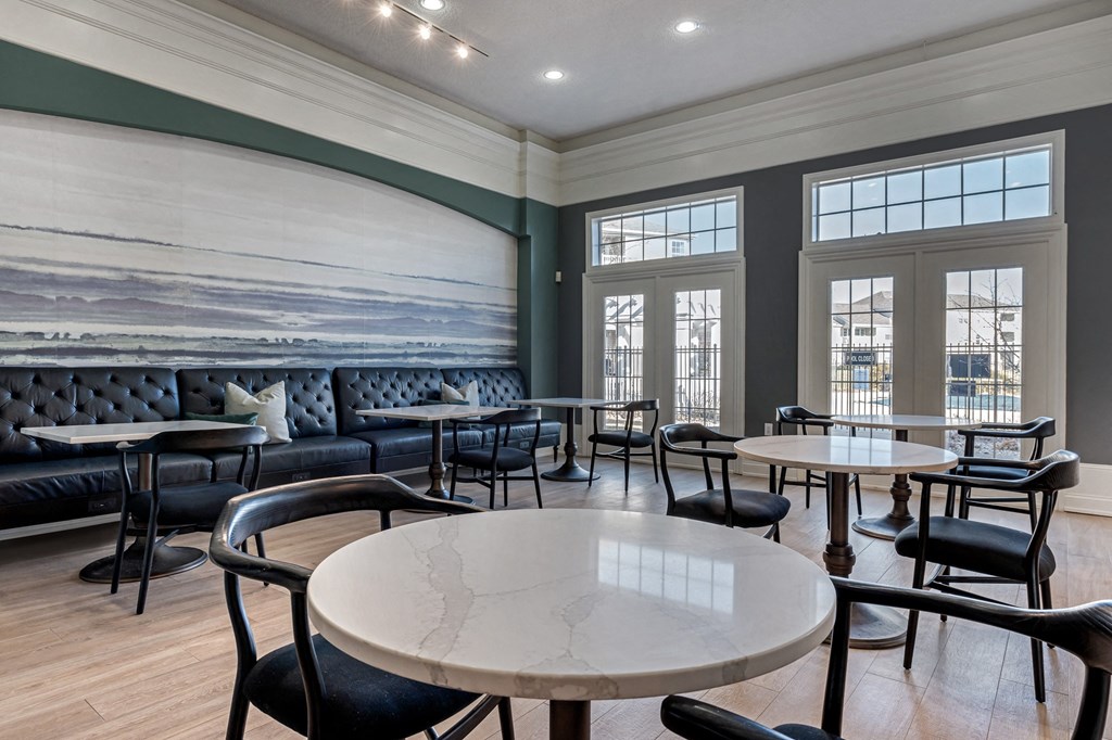 a dining room lounge with tables and chairs and a wall mural at Latitudes Apartments, Indiana