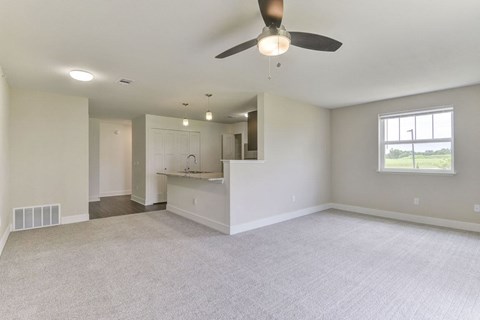 A spacious living and dining room with a ceiling fan and a window at Dodson Pointe Apartment Homes, Rogers, AR