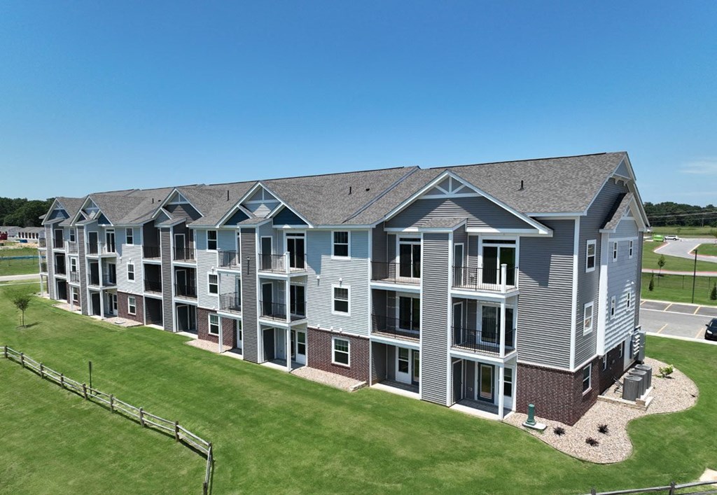 an aerial view of an apartment building with green grass at Dodson Pointe Apartment Homes, Rogers, AR, 72758
