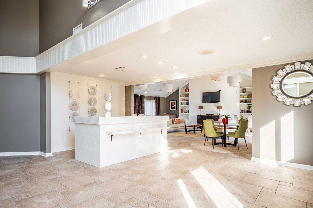 A living room with a white reception desk and a mirror on the wall