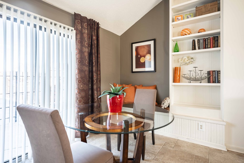 A dining room with a glass table and chairs