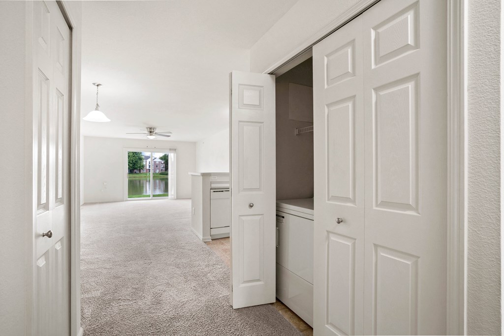 A white hallway with a carpeted floor and white walls.