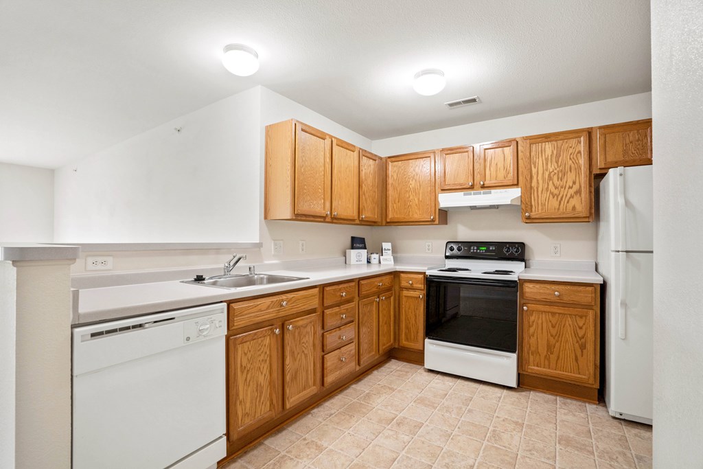 A kitchen with wooden cabinets and white appliances.