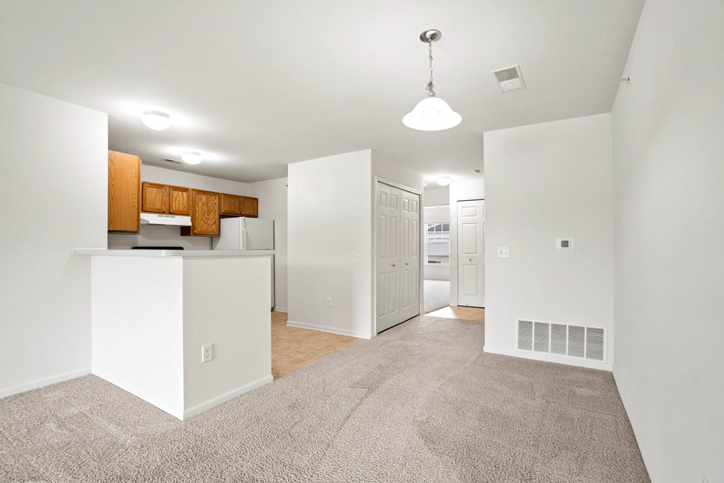 A white kitchen with a white island and a white fridge.