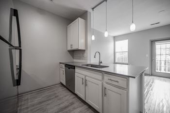 A modern kitchen with a refrigerator, sink, and cabinets.