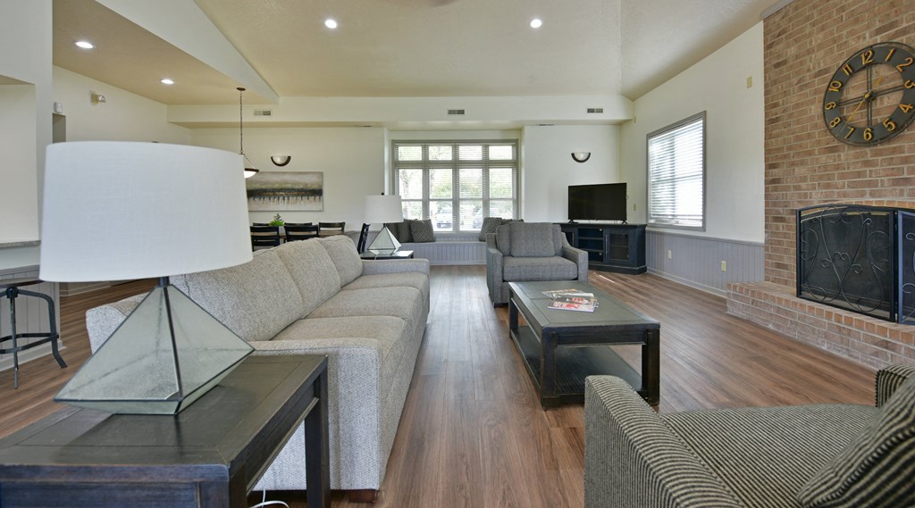 a living room with couches and a fireplace and a television at Heatherwood Apartments, Grand Blanc