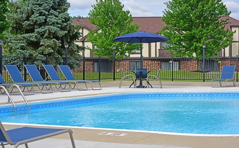 Our apartments have a swimming pool with chairs and umbrellas at Thornridge Apartments in Grand Blanc, Michigan