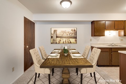 A dining room with a wooden table and chairs at Beacon Hill and Great Oaks Apartments, Rockford, Illinois