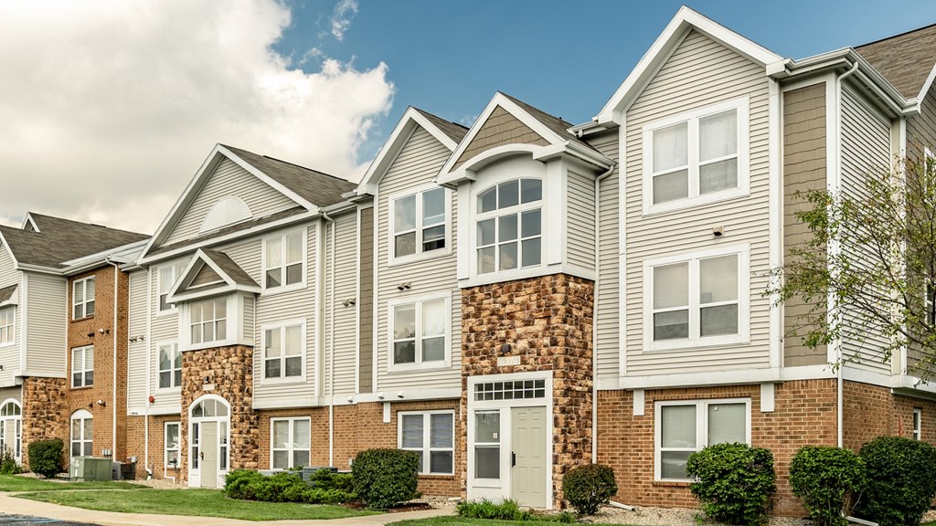 A row of townhouses with a mix of brick and siding exteriors