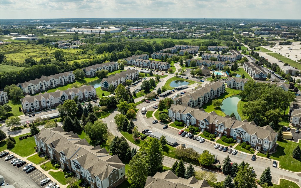 A bird's eye view of a residential area with houses, roads, and a swimming pool
