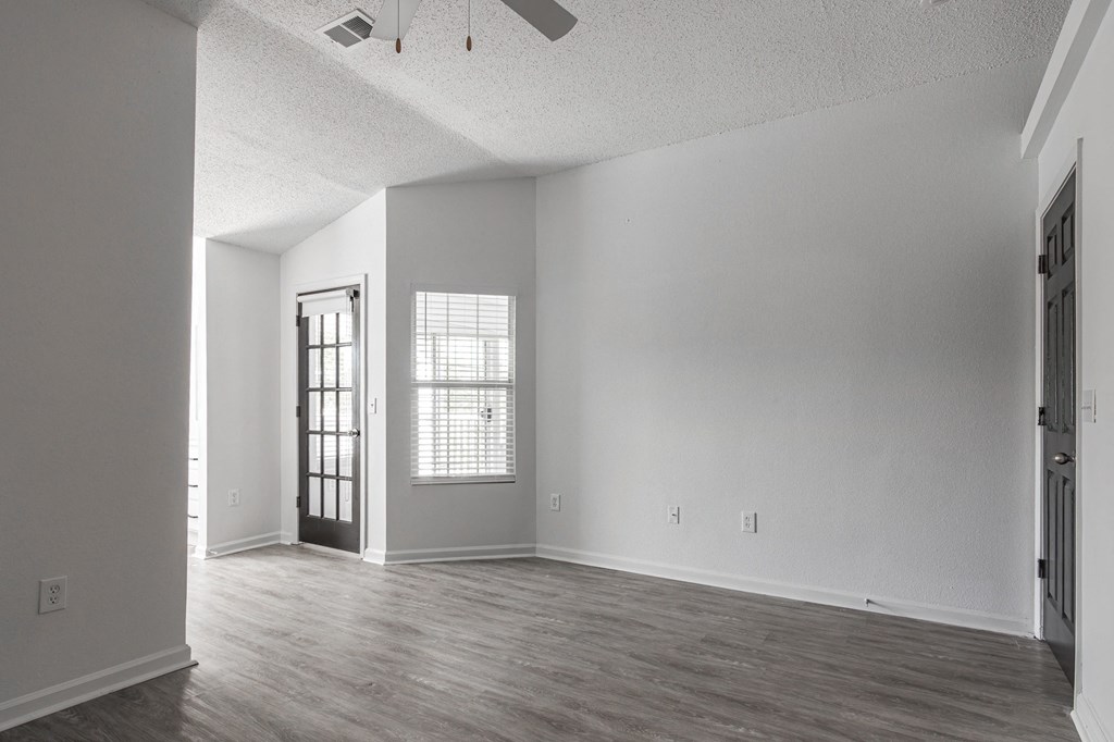 an empty living room with white walls and wood floors at Latitudes Apartments, Indianapolis, 46237