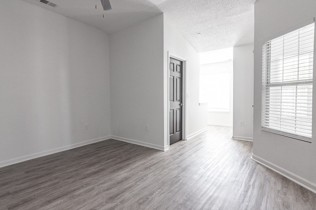 an empty living room with white walls and wood floors at Latitudes Apartments, Indianapolis, IN