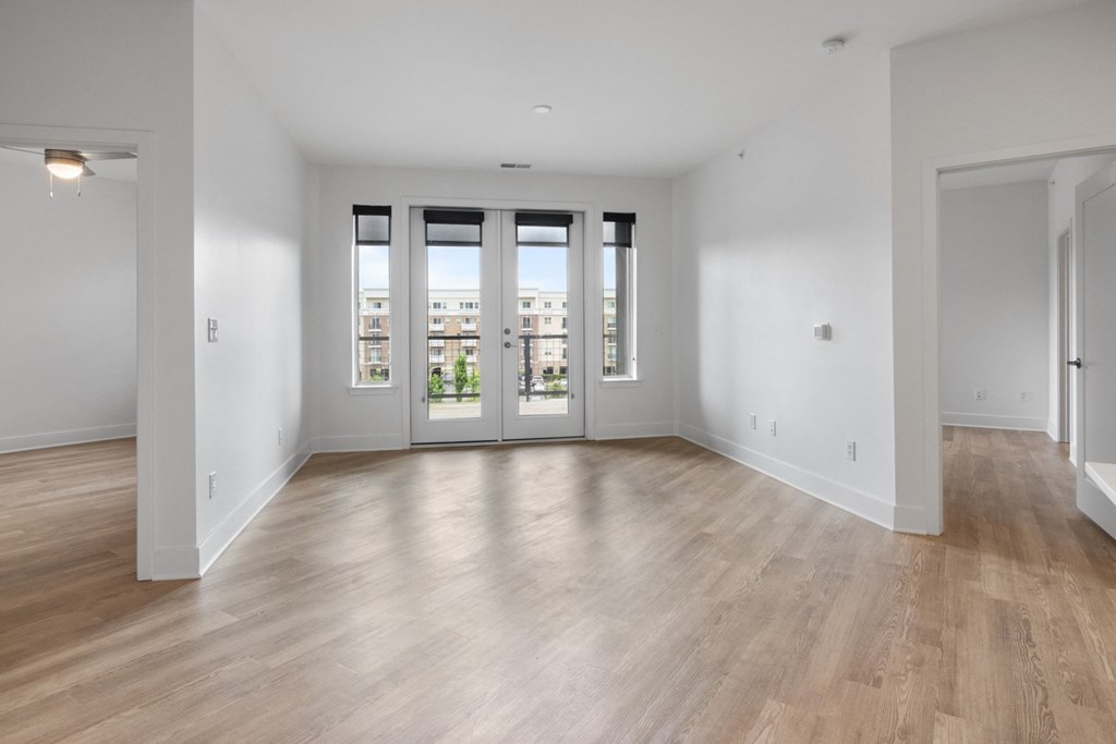 a living room with white walls and a door to a balcony in Carmel, IN