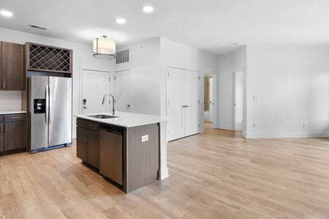 a renovated kitchen with a large island and a stainless steel refrigerator