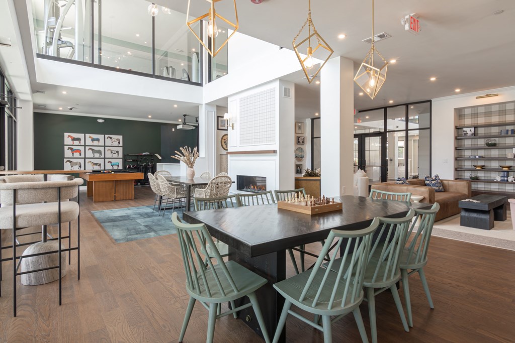 a dining room with a large table and chairs and a living area with a fireplace