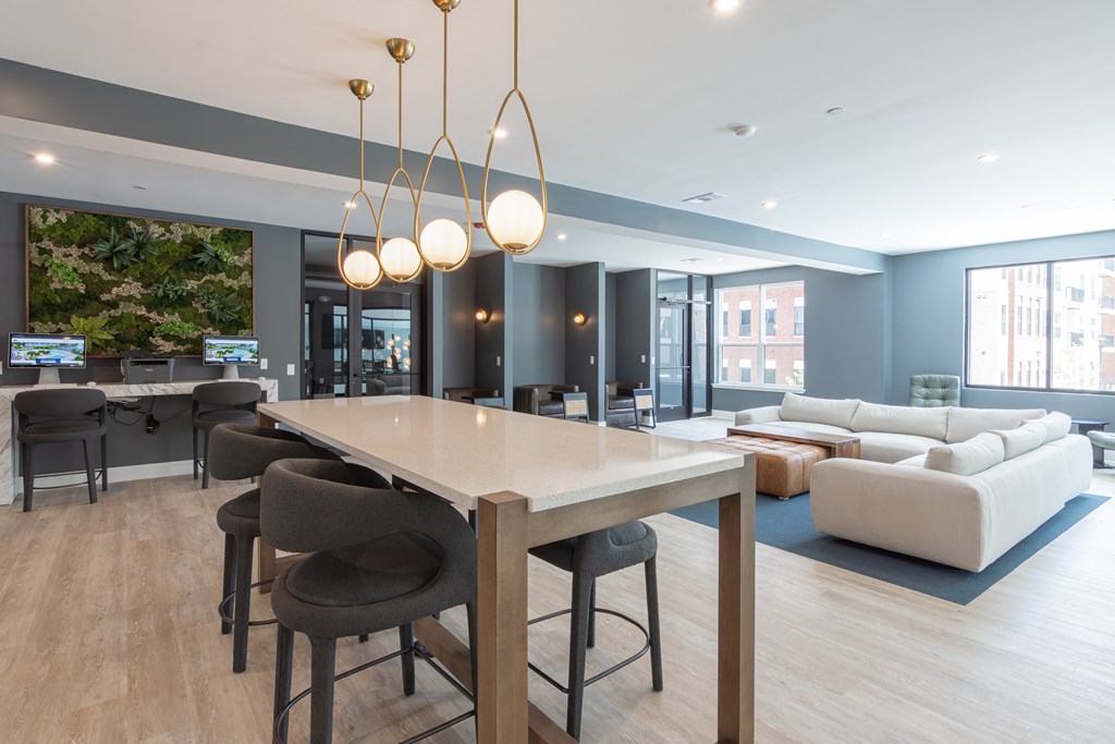 a communal area with a table and chairs and a living room with couches