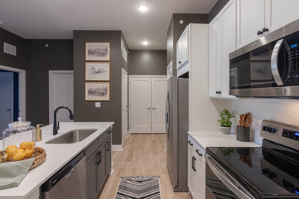 a kitchen with white cabinets and stainless steel appliances and a sink