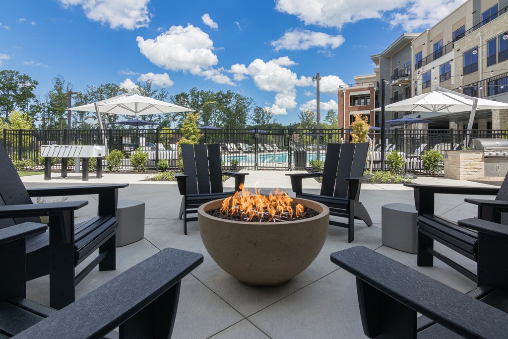 an outdoor patio with tables and chairs and a fire pit