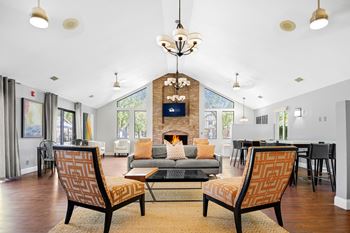 A living room with a fireplace and two chairs at Bay Pointe Apartments, Indiana, 47909