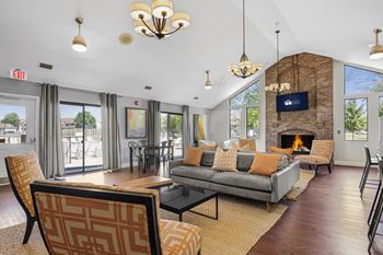A living room with a grey couch and a fireplace at Bay Pointe Apartments, Lafayette