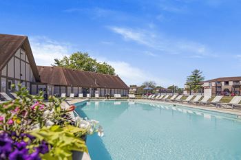 A large swimming pool with lounge chairs and a building in the background at Bay Pointe Apartments, Lafayette, 47909