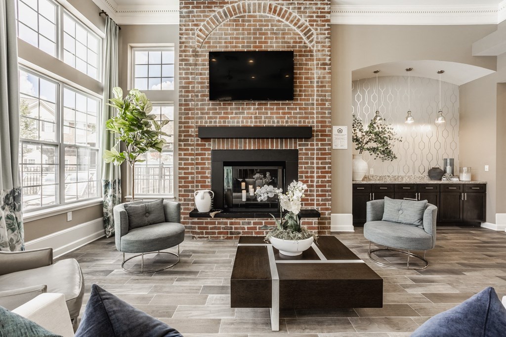 a living room with couches and a coffee table and a brick fireplace at The Avenue at Polaris Apartments, Columbus, OH