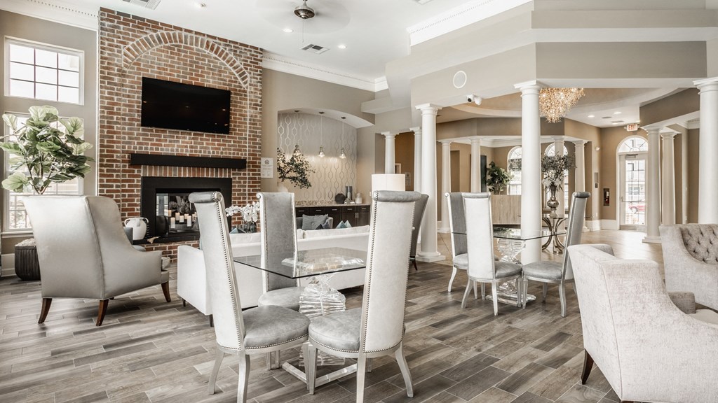 a dining room with a table and chairs and a brick fireplace at The Avenue at Polaris Apartments, Columbus, OH