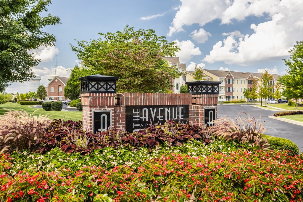 sign with flowers and buildings in the background at The Avenue at Polaris Apartments, Columbus, OH