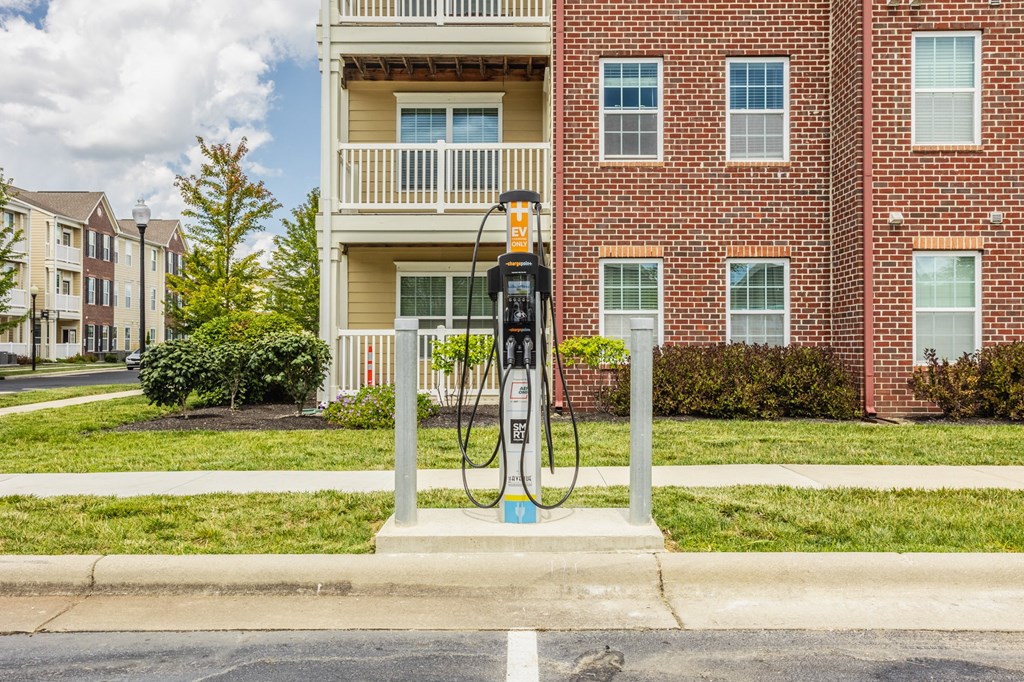 a gas pump sitting in front of a red brick building at The Avenue at Polaris Apartments, Columbus, OH