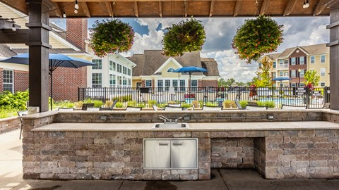 a large outdoor kitchen with a sink and a patio with umbrellas
