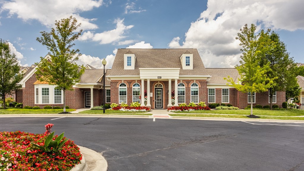a large brick house with a driveway in front of it at The Avenue at Polaris Apartments, Columbus, OH