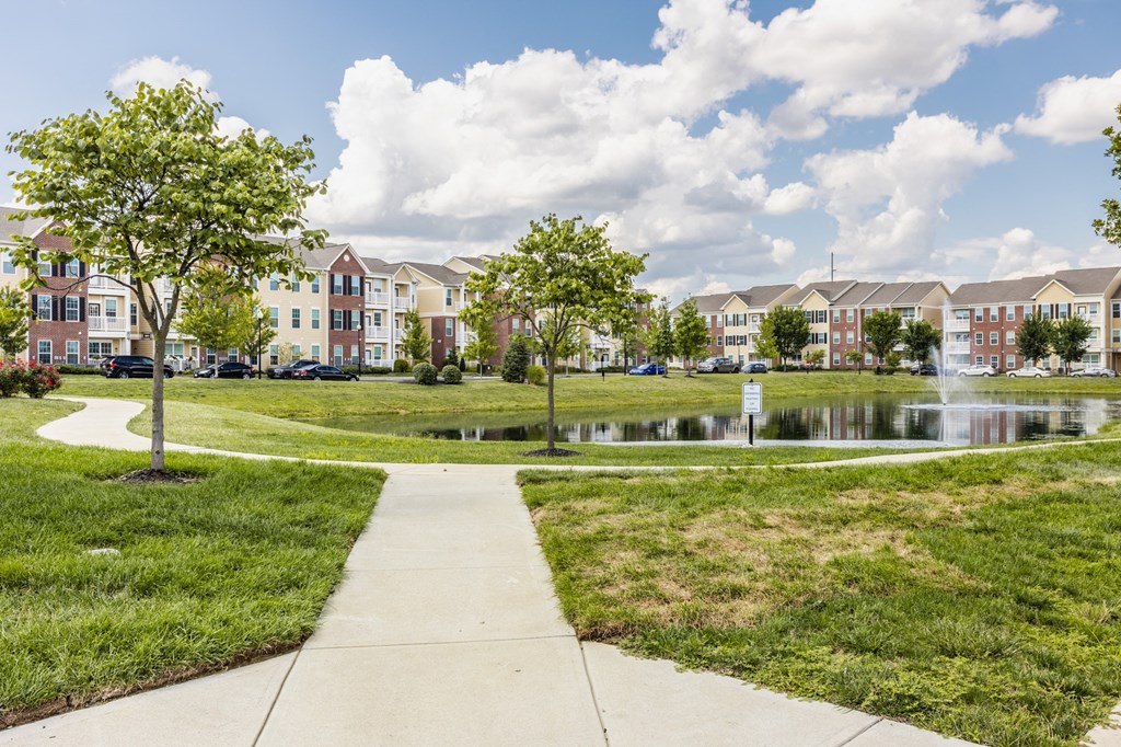 a park with a pond in front of an apartment building at The Avenue at Polaris Apartments, Columbus, OH
