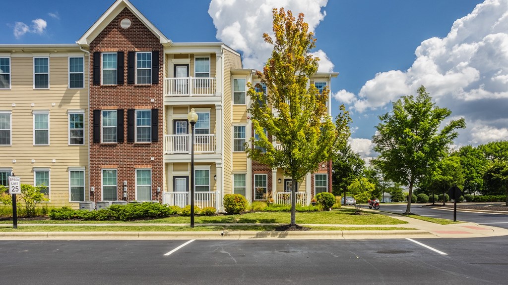 an apartment building on the corner of a street with trees at The Avenue at Polaris Apartments, Columbus, OH