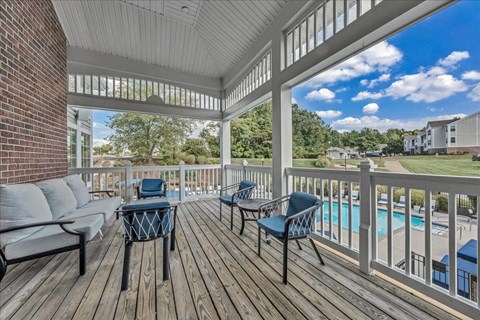 a covered porch with a pool and furniture on it at The Vinings Apartments in Richmond, VA
