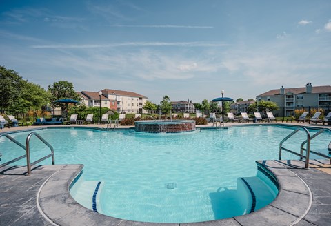 A large outdoor swimming pool with a metal railing around it.