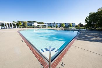 A large swimming pool with a red brick border.