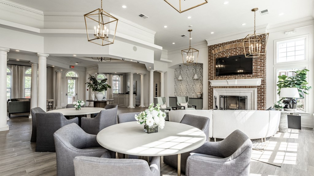 Gray chairs white tables and TV in clubhouse at Alexandria of Carmel Apartments, Indiana, 46032