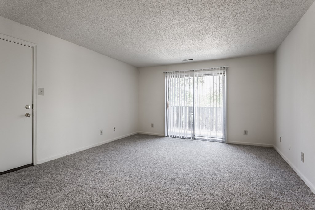 an empty bedroom with a door leading to a balcony at Bavarian Village Apartments, Indiana, 46235