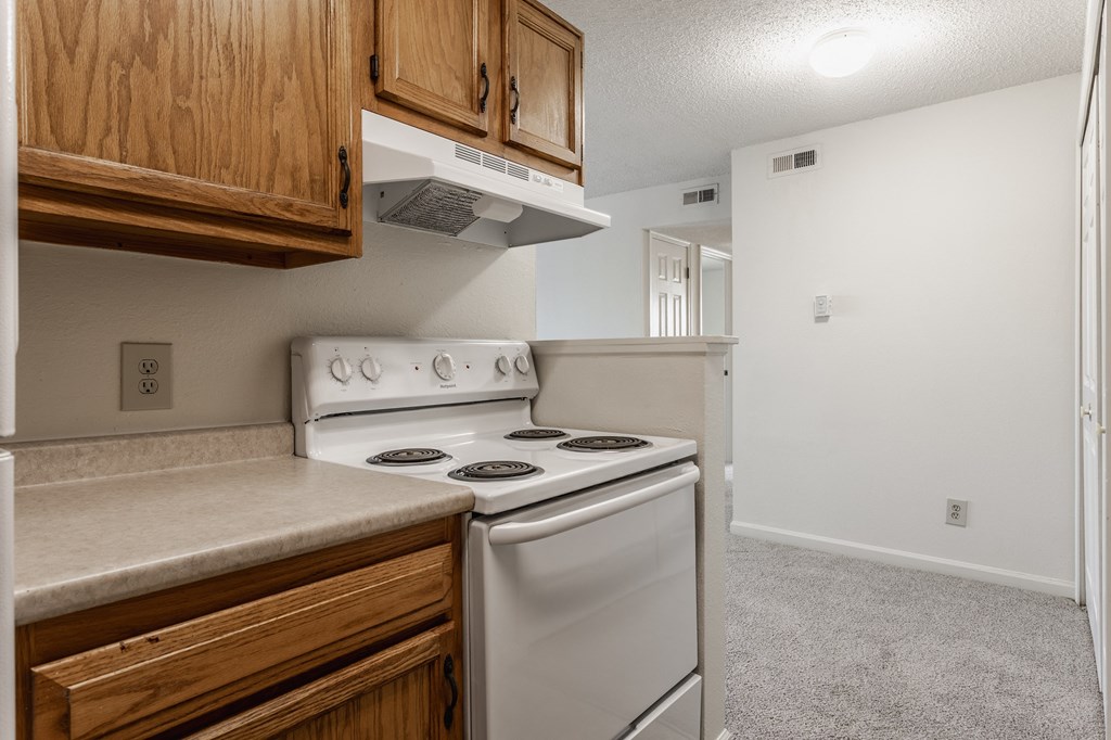 a kitchen with white appliances and wooden cabinets at Bavarian Village Apartments, Indianapolis