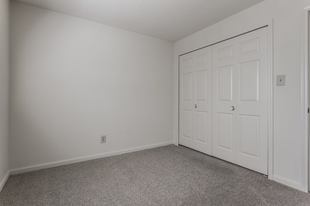 a bedroom with a closet and carpeted flooring at Bavarian Village Apartments, Indianapolis