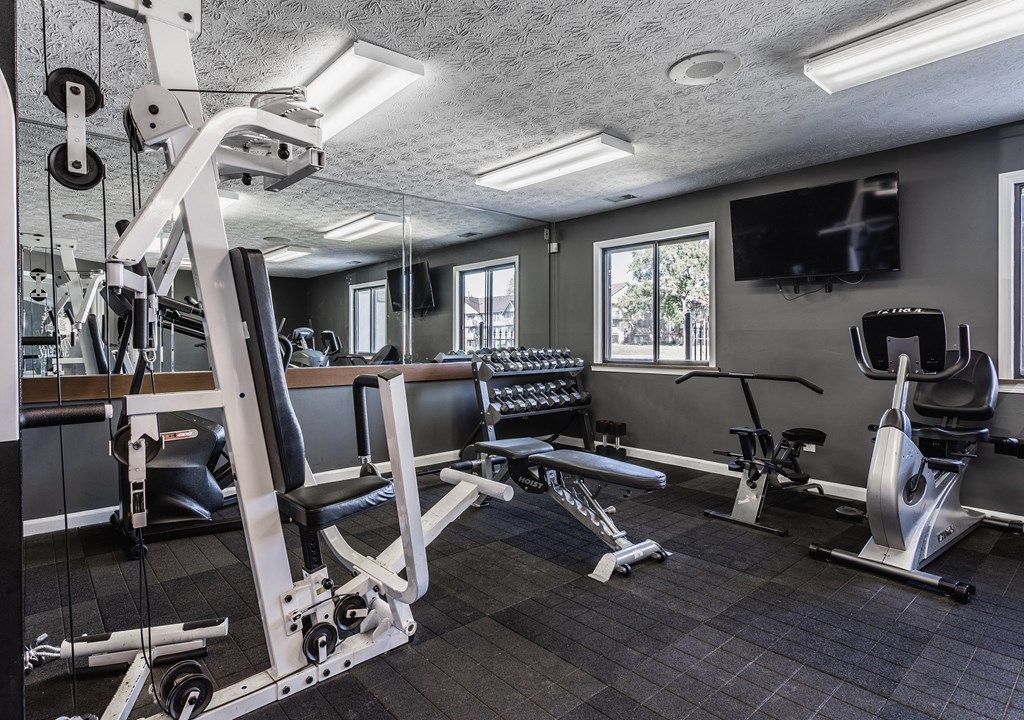 a gym with exercise equipment and a flat screen tv at Bavarian Village Apartments, Indianapolis