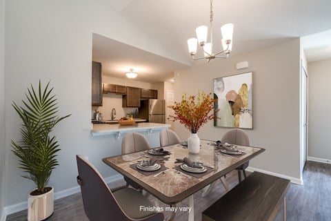 a dining room with a table and chairs and a kitchen  at Killian Lakes Apartments and Townhomes, South Carolina