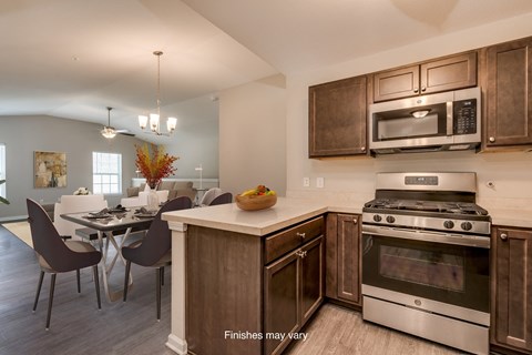 a kitchen and dining room with stainless steel appliances and wooden cabinets  at Killian Lakes Apartments and Townhomes, Columbia