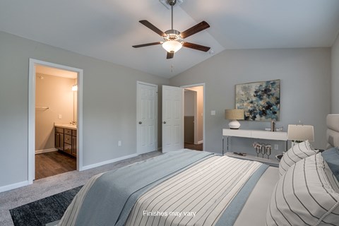 a bedroom with a large bed and a ceiling fan  at Killian Lakes Apartments and Townhomes, South Carolina