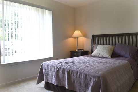 a bedroom with a bed and a window  at LakePointe Apartments, Batavia, OH, 45103