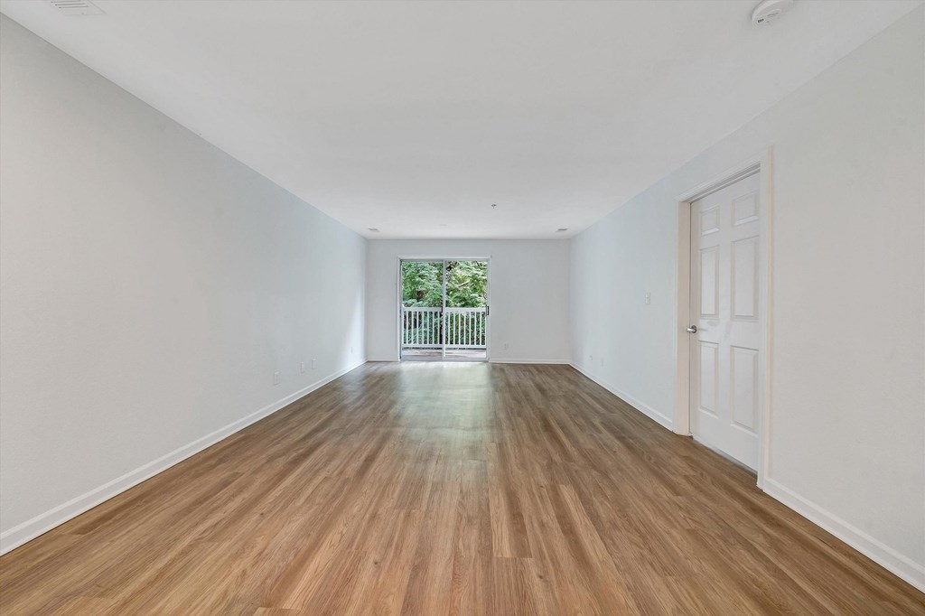 a bedroom with hardwood floors and white walls  at The Vinings Apartments, Richmond, 23234