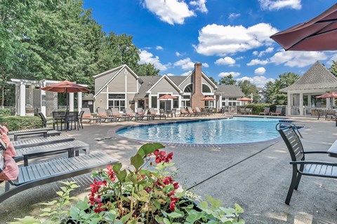 the resort style pool is surrounded by chairs and umbrellas at Trophy Club at Bellgrade, Midlothian, VA, 23113