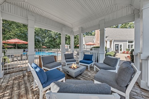 a covered porch with couches and chairs and a fire pit at Trophy Club at Bellgrade, Midlothian, VA, 23113