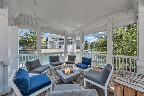 a covered porch with couches and chairs and a fire pit at Trophy Club at Bellgrade, Midlothian, VA, 23113