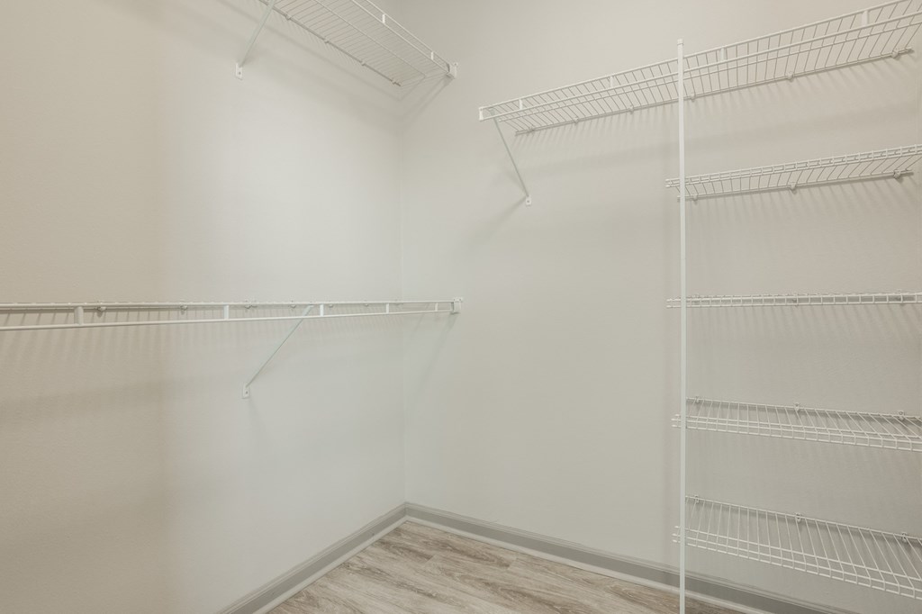 an empty closet with white walls and shelves and a wood floor at The Avenue at Polaris Apartments, Columbus, OH